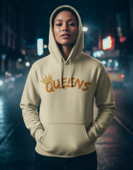 Person wearing a beige hoodie with 'QUEENS' printed on it against a blurred city street background.
